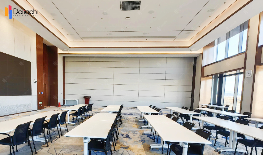 The minimalist, pure white vertical lift wall in the spacious classroom