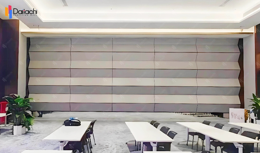 The classroom features a simple, solid-color vertical lift wall.